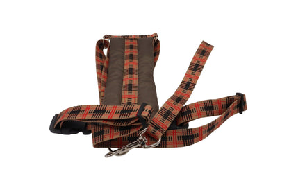 A light brown car safety harness with black and red patterned webbing and handle