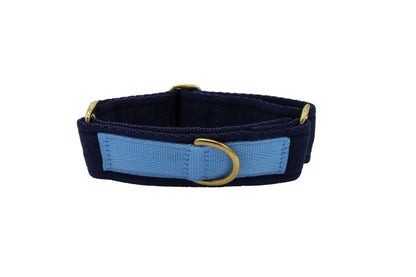 A wide navy dog collar with a light blue back piece to hold the ring to connect to a lead with brass fittings. This looks similar to a martingale collar but does not tighten in the same way.