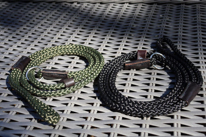 A black and an olive green slip lead  on rattan furniture with a low sun lighting and shadows of tree branches in the background giving the photo a low light effect and reflecting the leads.