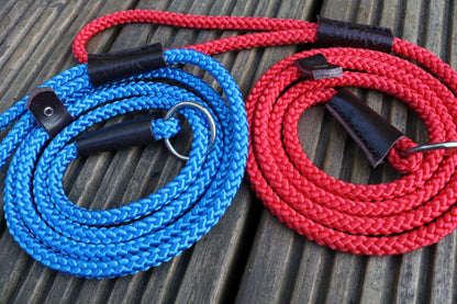 A close up on our red and our blue slip leads on wooden decking showing the detail of the braid and embossing on the handle.