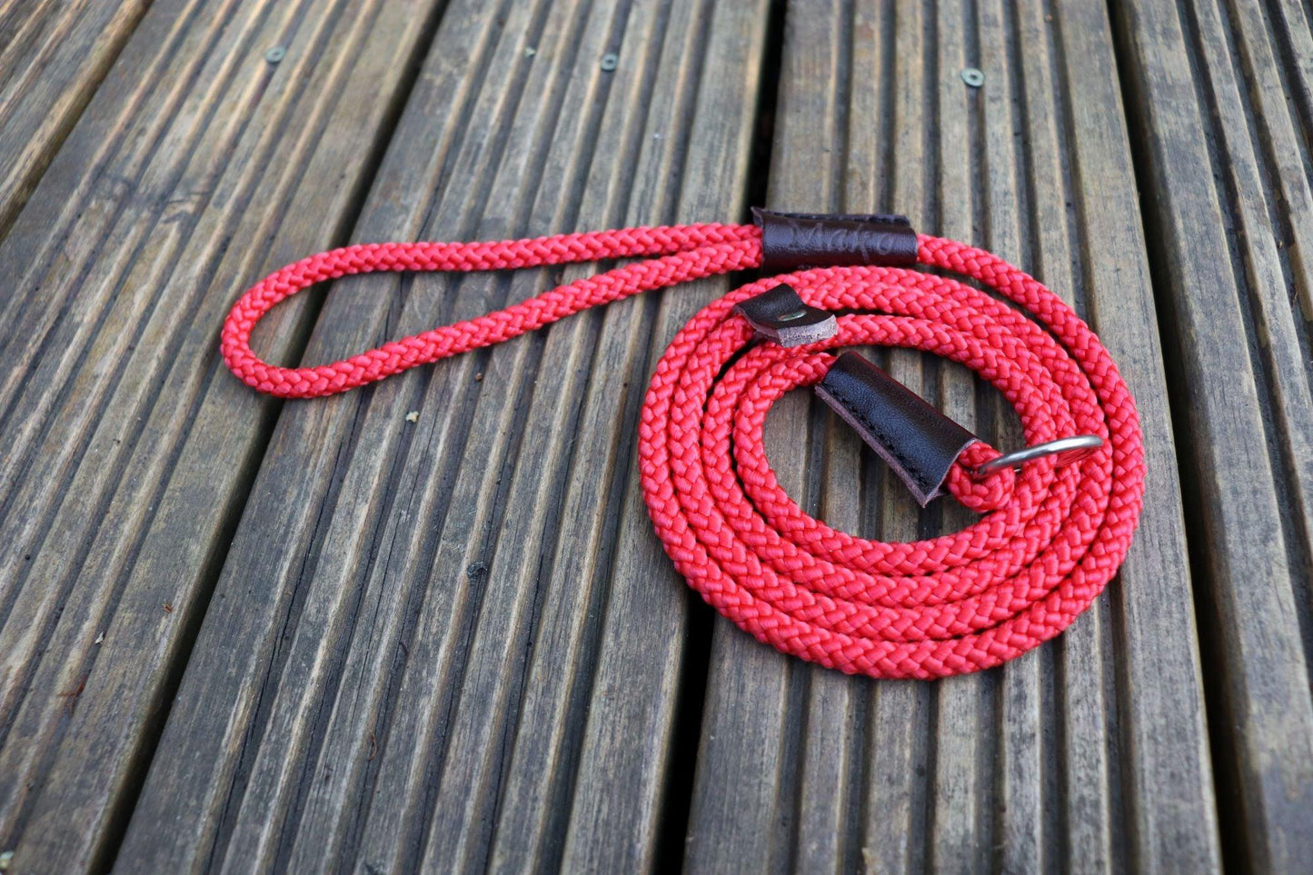 A tightly wound spiral of our red slip lead on a wooden decking.