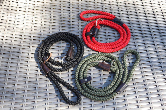 A black, olive green, and red 12mm braid slip lead on rattan furniture. The three leads are in a spiral.